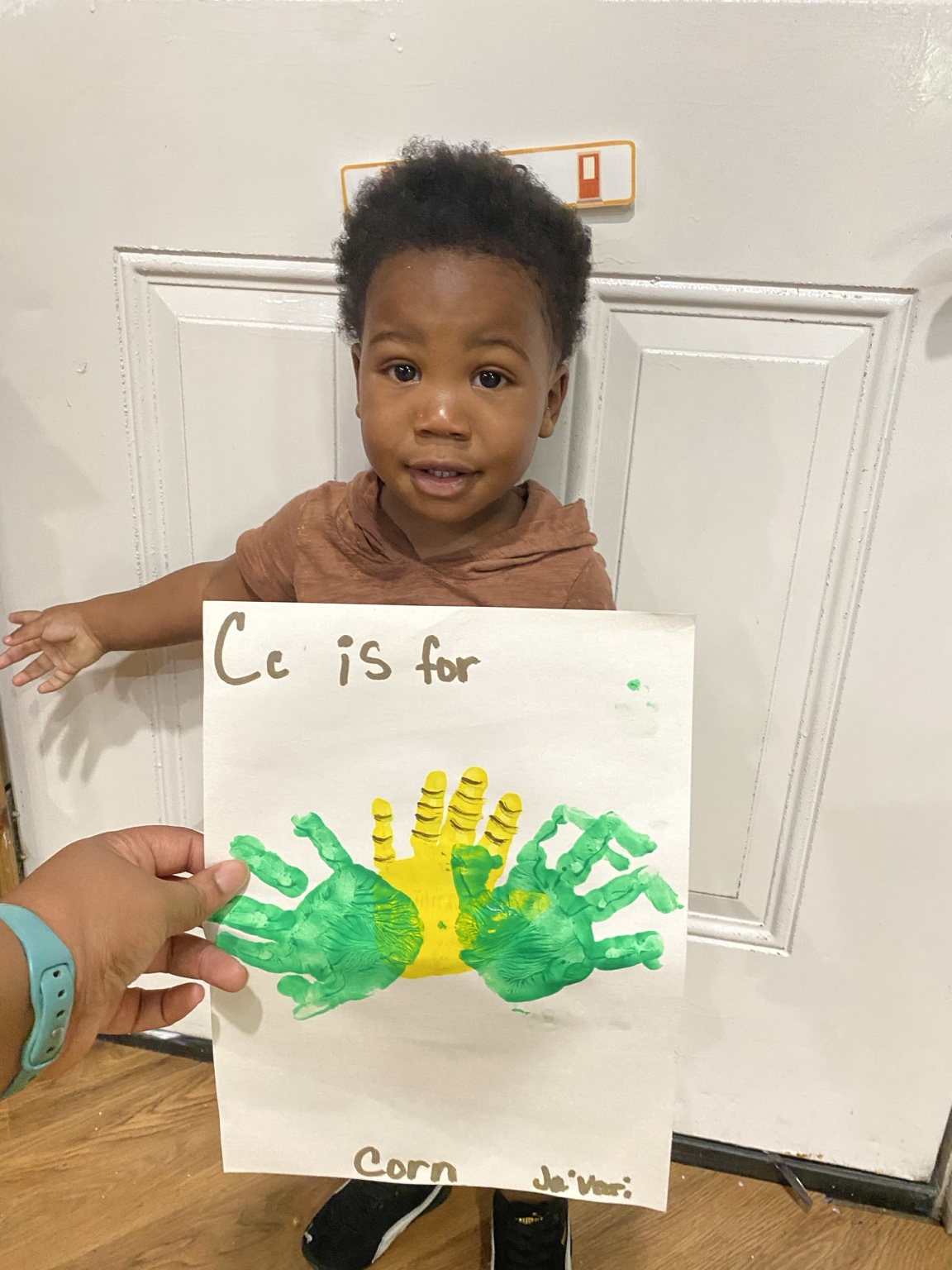 Child showing corn handprint artwork