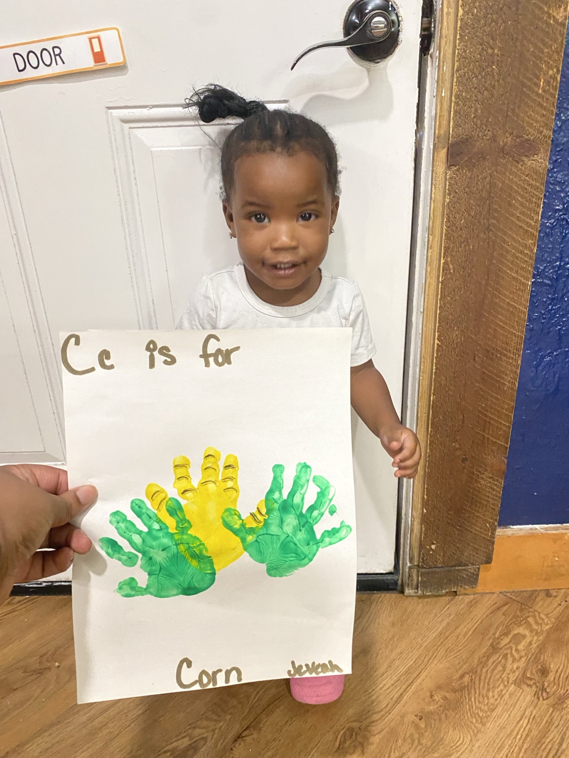 Child showing a second corn handprint artwork